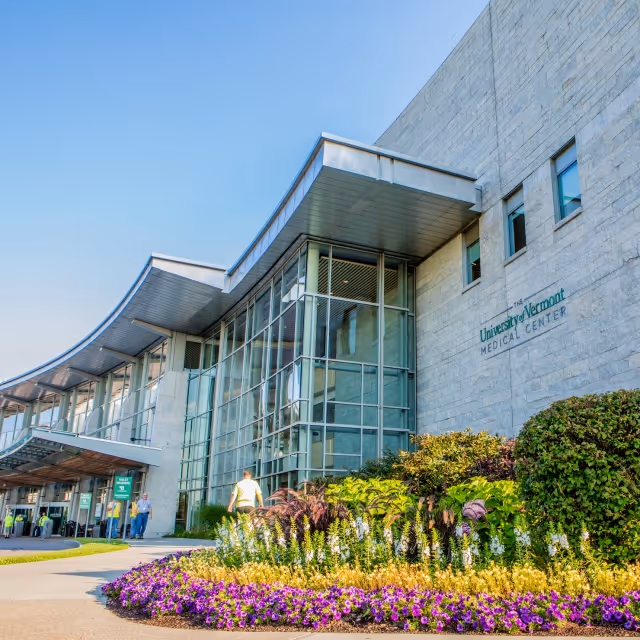 Exterior view of University of Vermont Medical Center building with glass entrance and landscaping.
