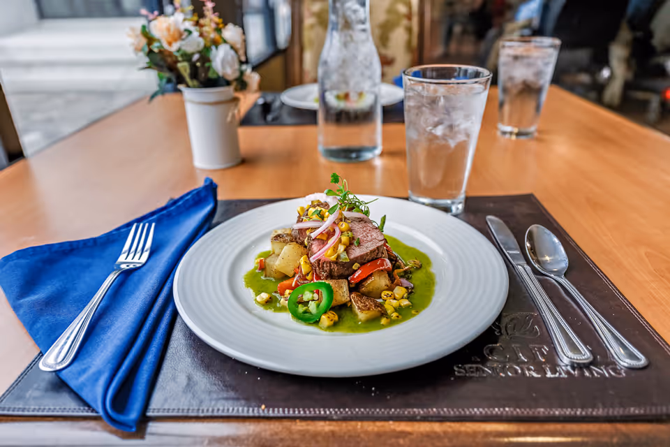 Gourmet plated dish on a wooden dining table with a blue napkin.