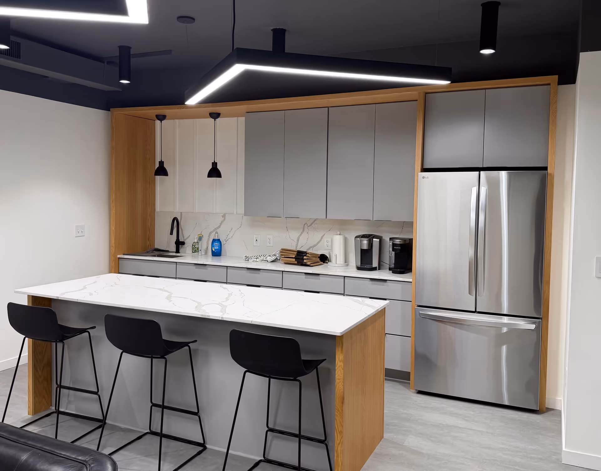 Modern kitchen at Amada Senior Care with island, gray cabinets, and stainless appliances.