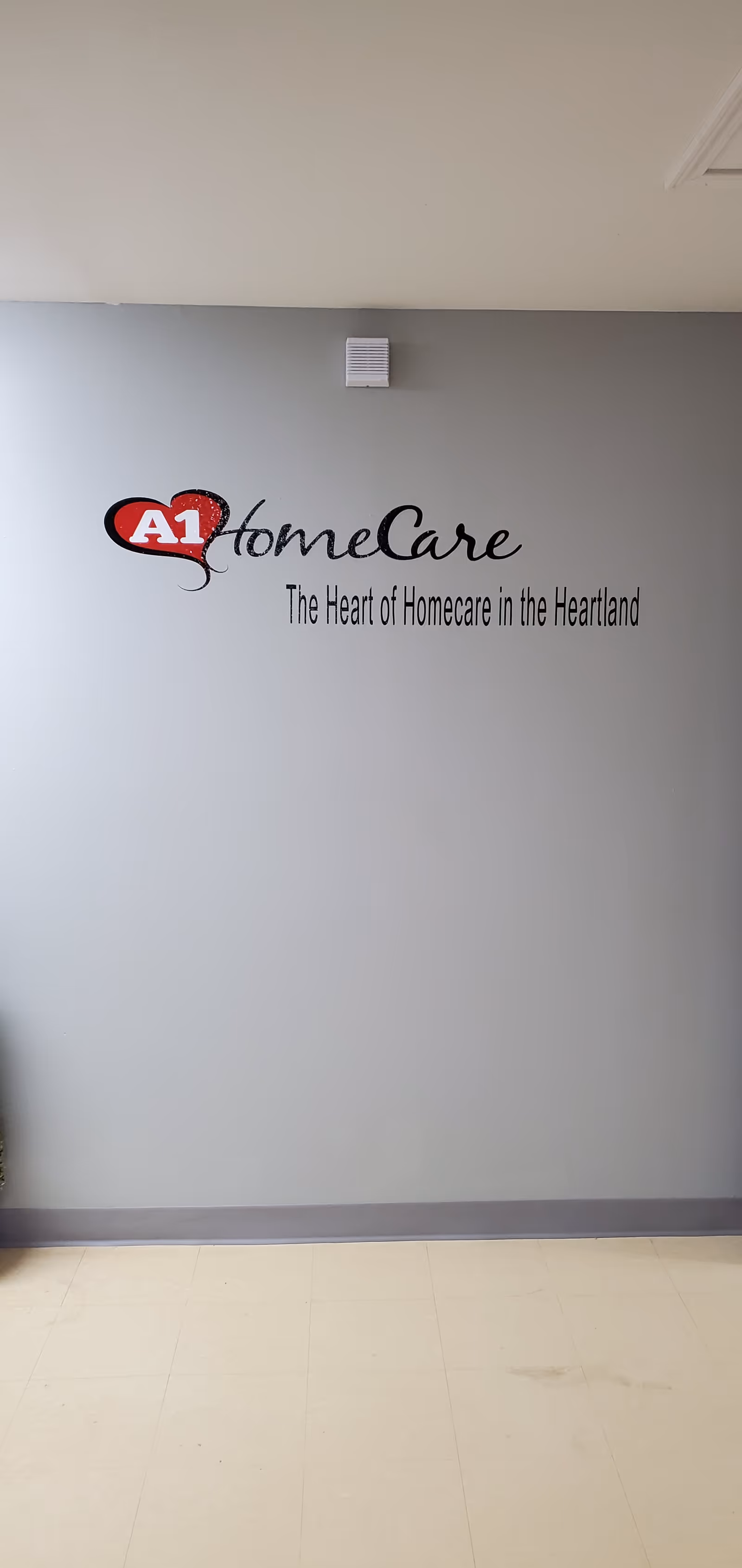Interior wall displays the A1 HomeCare logo and slogan on a gray backdrop.