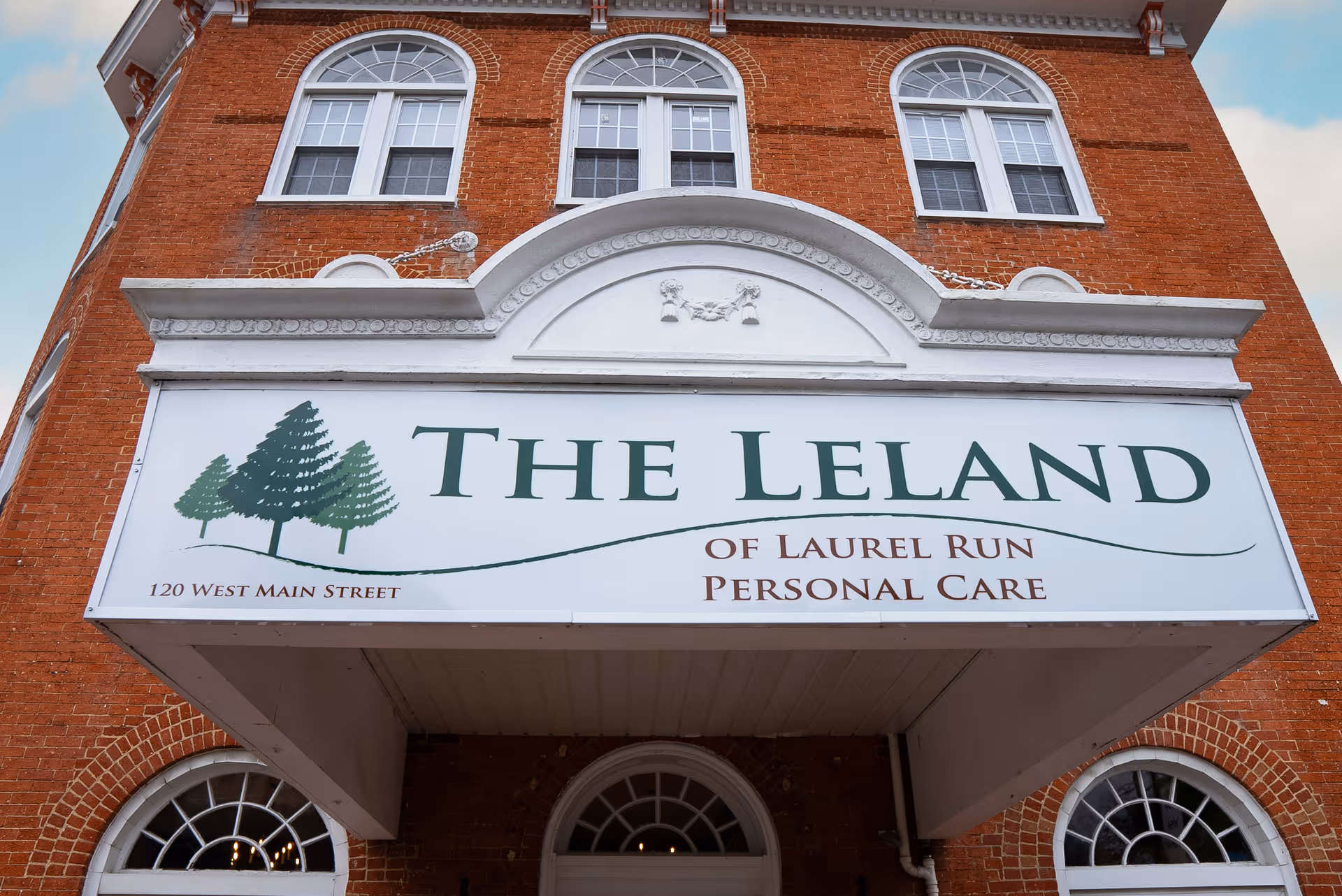 Brick building with a large sign reading The Leland of Laurel Run Personal Care.