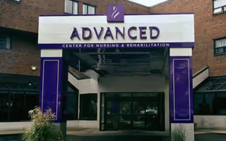 Front entrance of Advanced Center for Nursing and Rehabilitation with glass doors and purple accents.