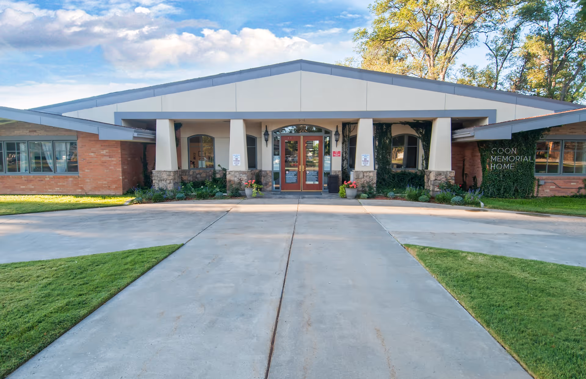 Front view of Coon Memorial Home Health and Hospice entrance with red doors and stone accents.