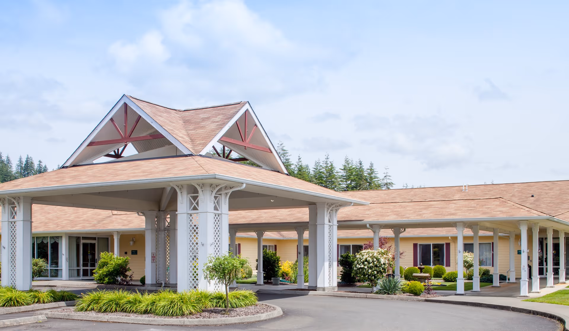 Exterior view of Montesano Health and Rehabilitation Center with covered entrance and landscaped surroundings.