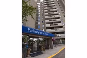 Tall building exterior with a blue Pathways on the Park canopy at the entrance