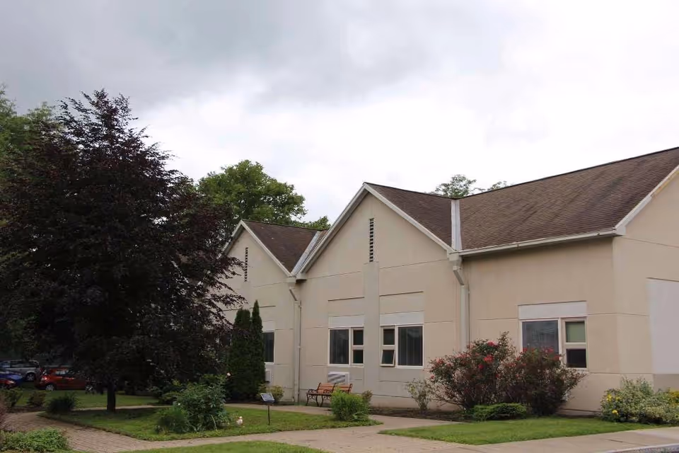 Exterior view of Beechtree Center building with beige walls, gabled roof, and landscaped front yard.
