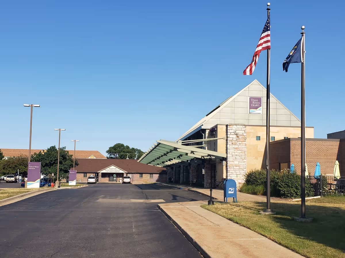 Exterior view of Three Rivers Health Homecare and Hospice with flags, entrance canopy, and parking.
