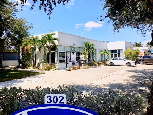 Front view of Ability Nursing Inc facility, a single-story building with palm trees.