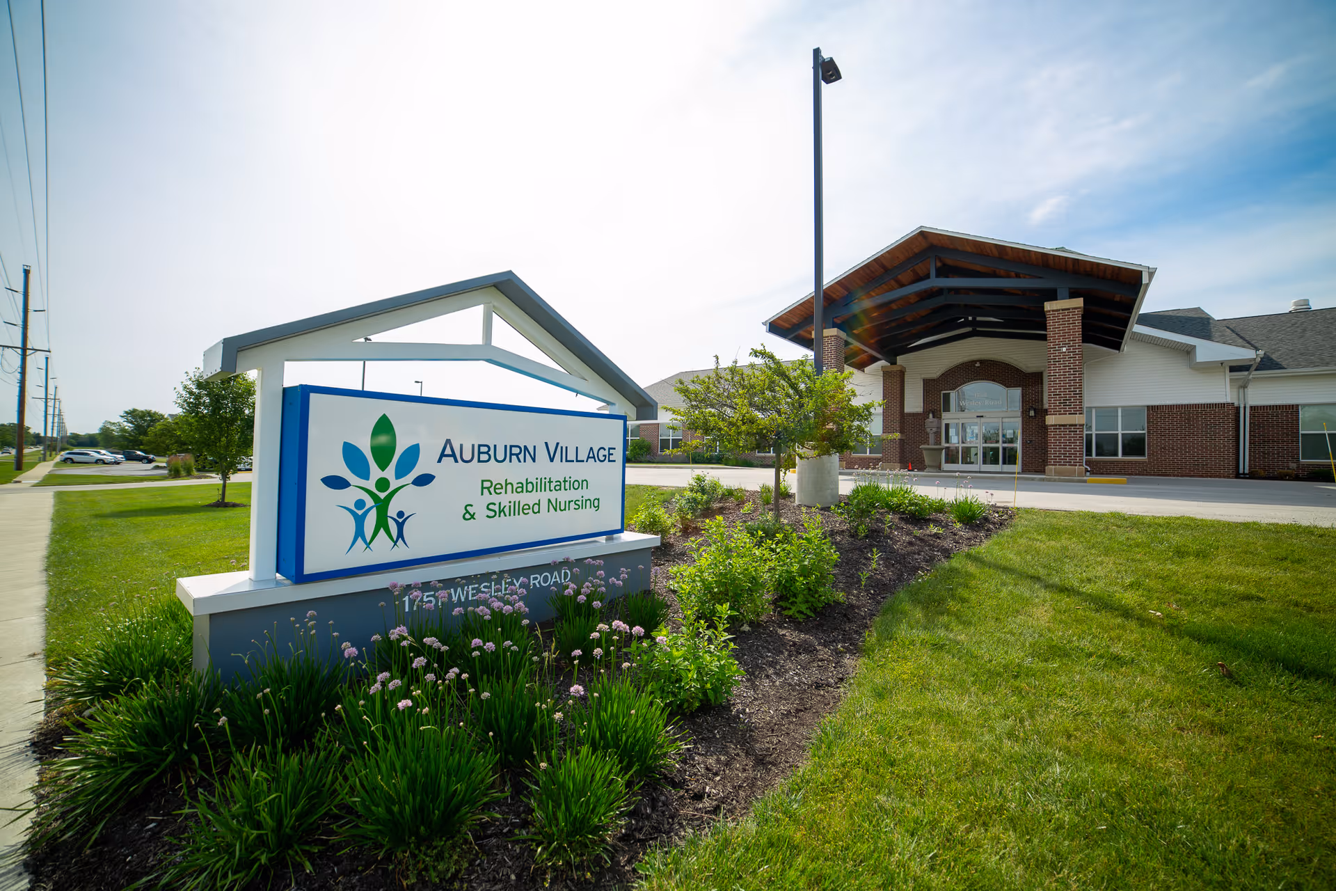 Auburn Village exterior with a welcoming entrance and landscaped sign.