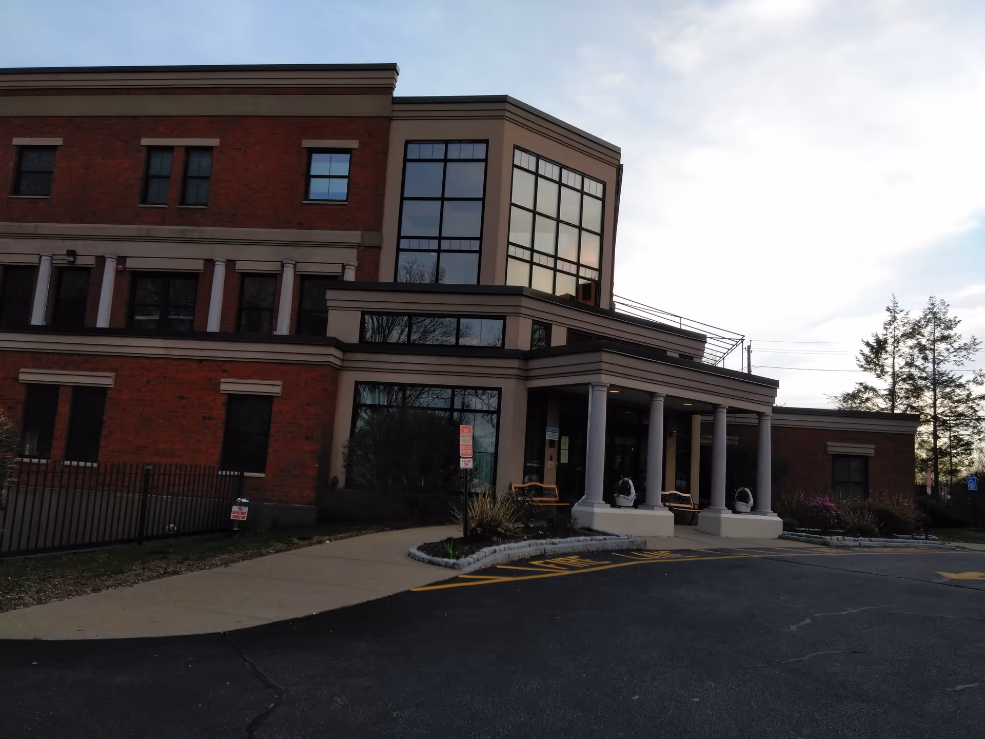 Front exterior of a brick senior living center with a columned porch.