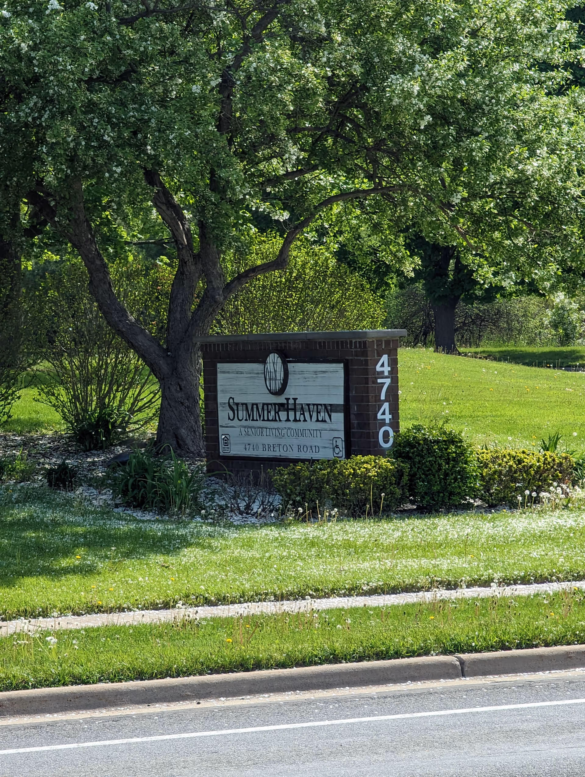 A brick sign for Summer Haven Senior Living Community sits among trees and a grassy lawn.