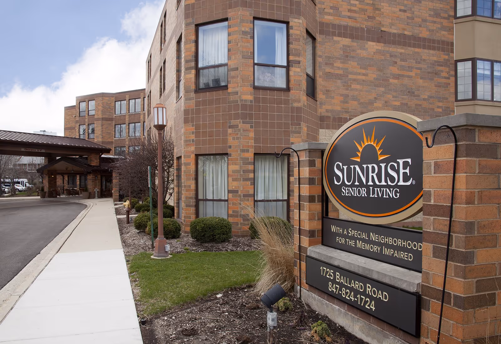 Exterior view of Sunrise Senior Living facility with brick building and front sign.