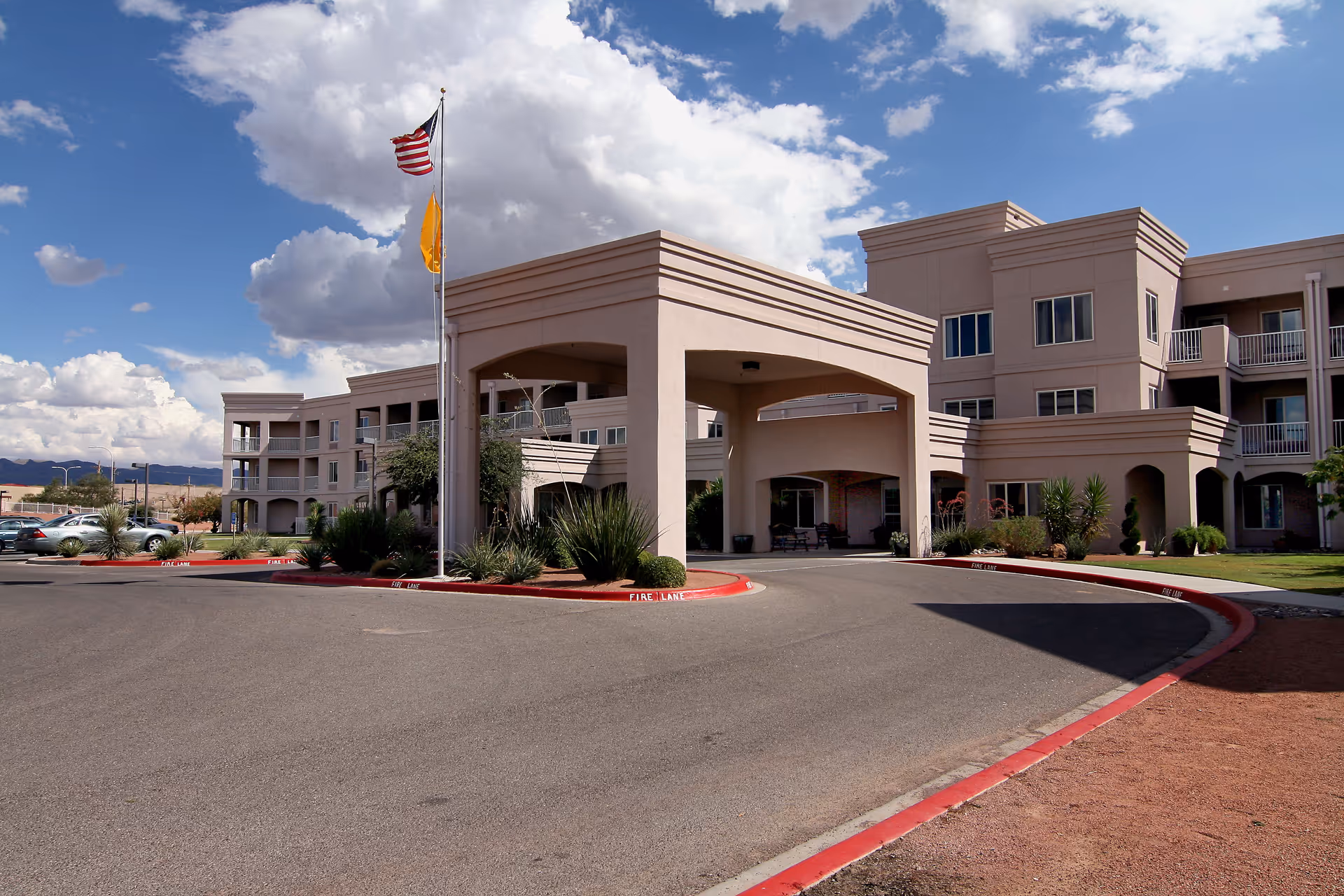 Front view of Solstice Senior Living at Las Cruces with entrance archway and curved driveway