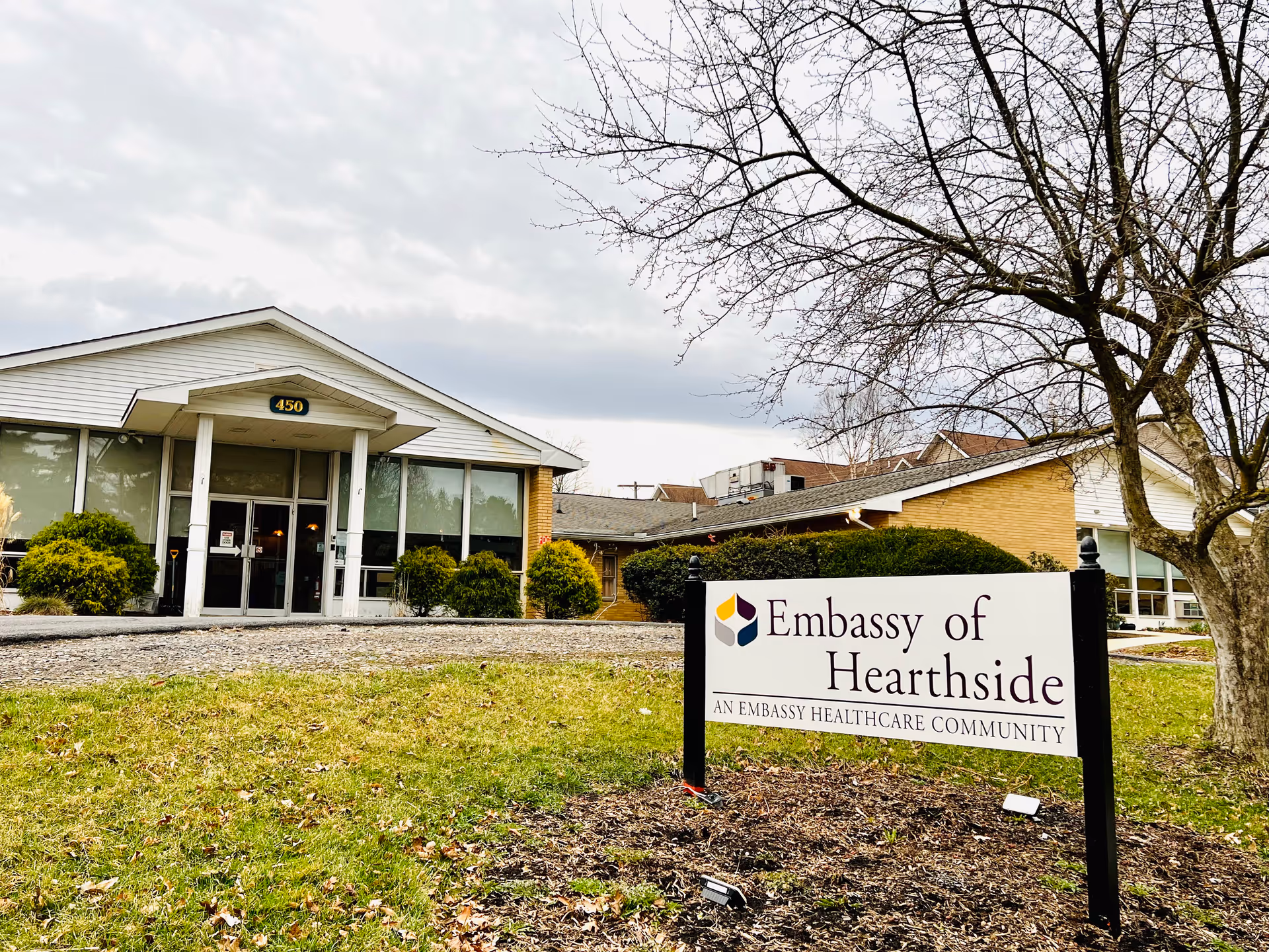 Front exterior of a healthcare facility with Embassy of Hearthside sign and main entrance