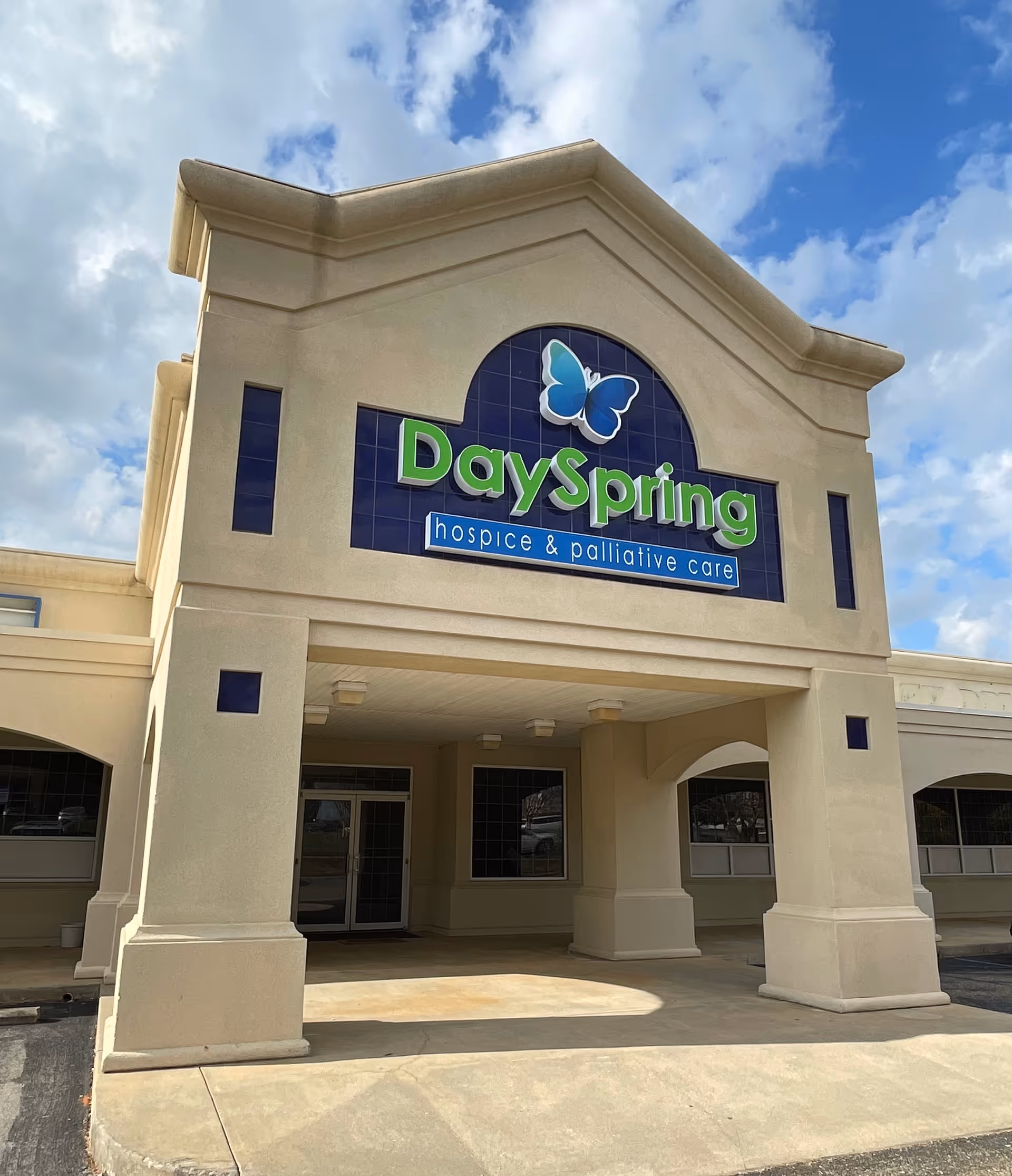 This is the front view of DaySpring hospice building with a green logo and butterfly.