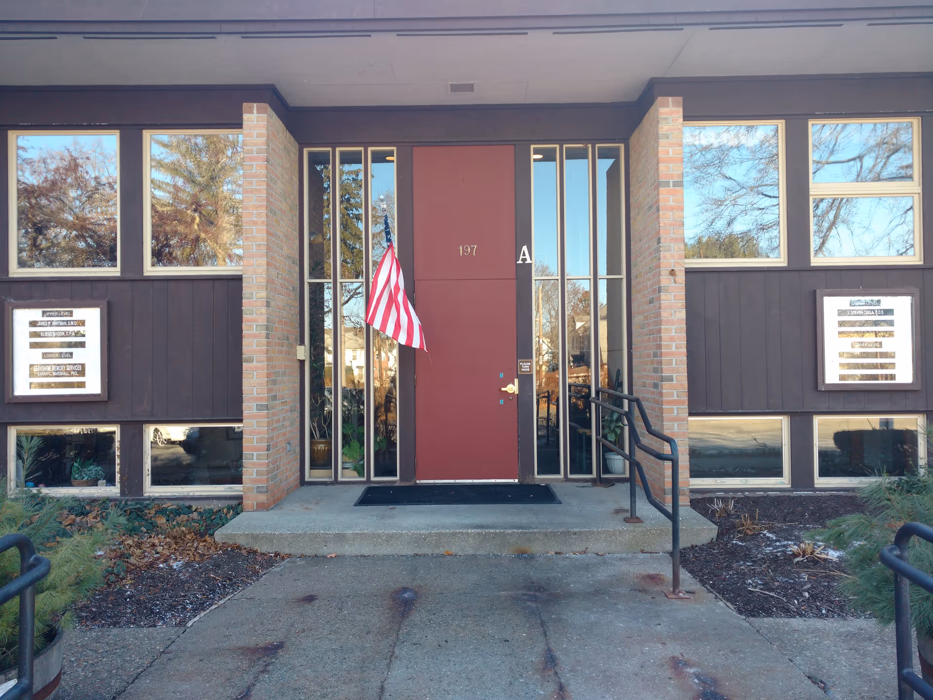 Exterior view of Visiting Angels Senior Home Care Pittsfield entrance with red door and American flag