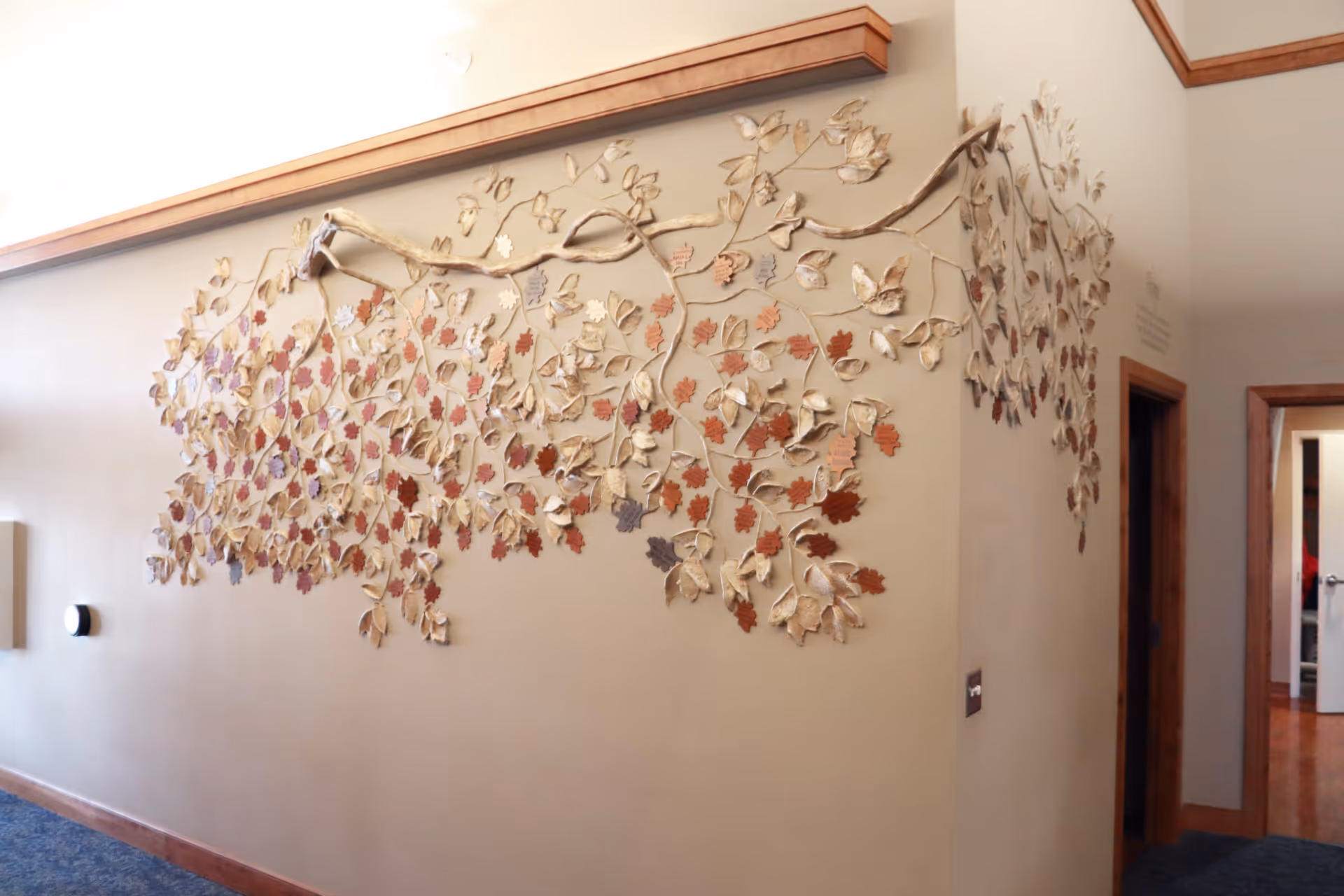 Interior hallway with a large decorative leaf sculpture spanning the wall.