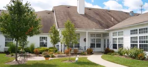 Front exterior view of Brookdale Barberton senior living facility with walkway and greenery