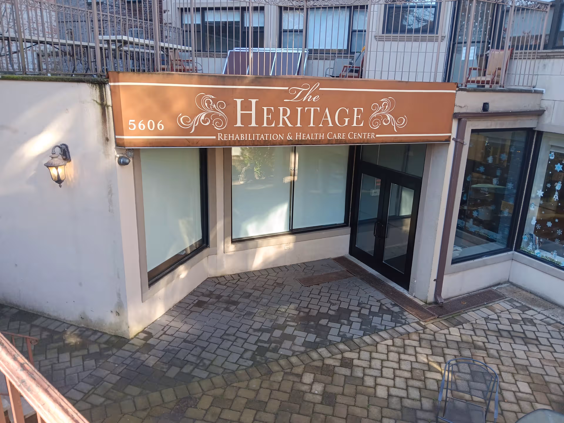Entrance to The Heritage Rehabilitation & Health Care Center with a brown sign above doors.
