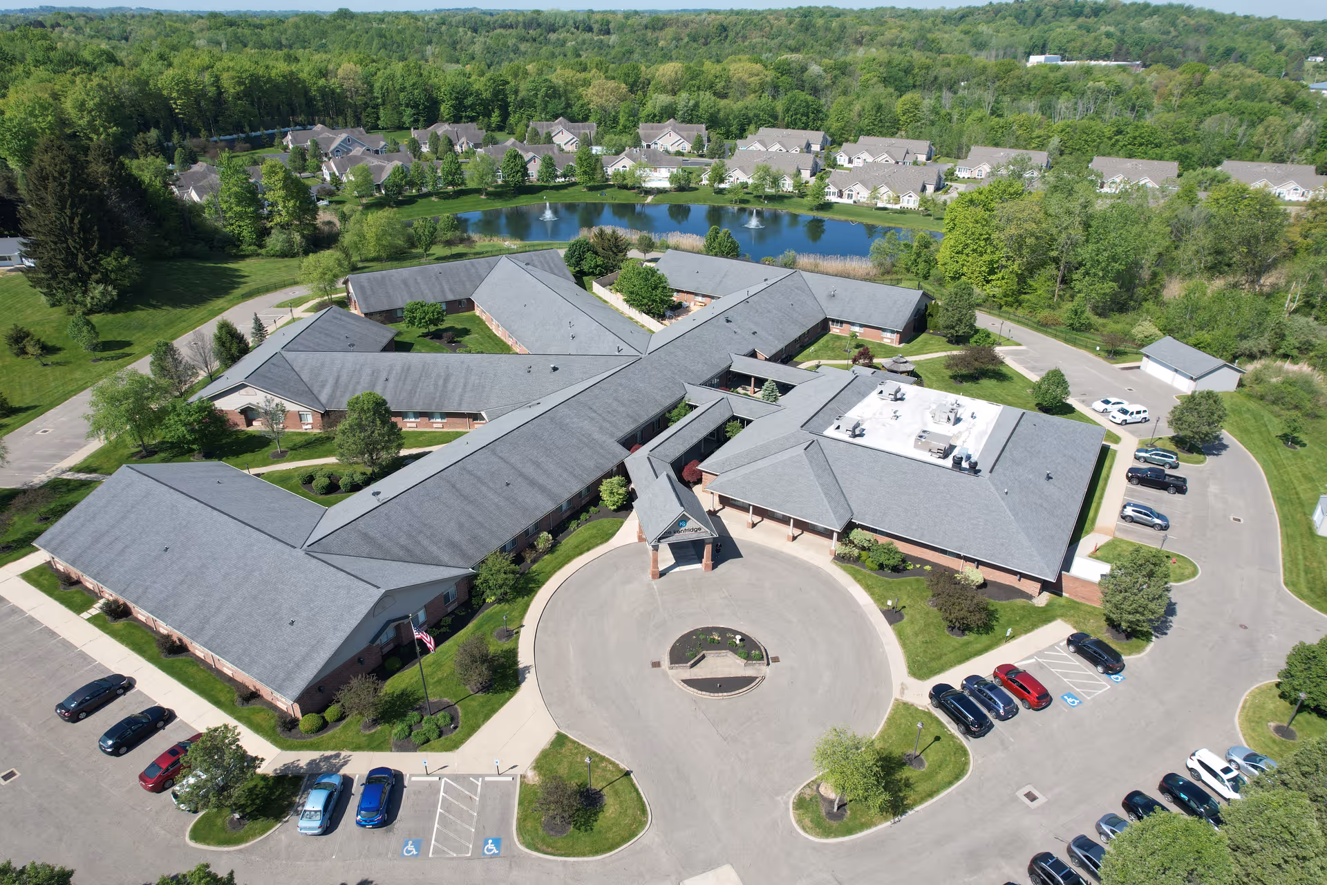 Aerial view of a large senior living campus with interconnected buildings, parking, and landscaping.