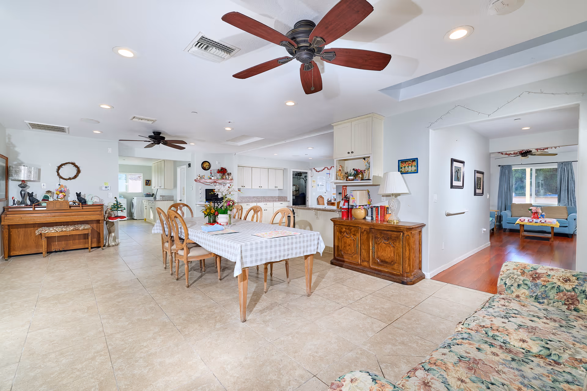 Bright open common area with dining table, kitchen, and living room in Oceanside Elderly Care Home.