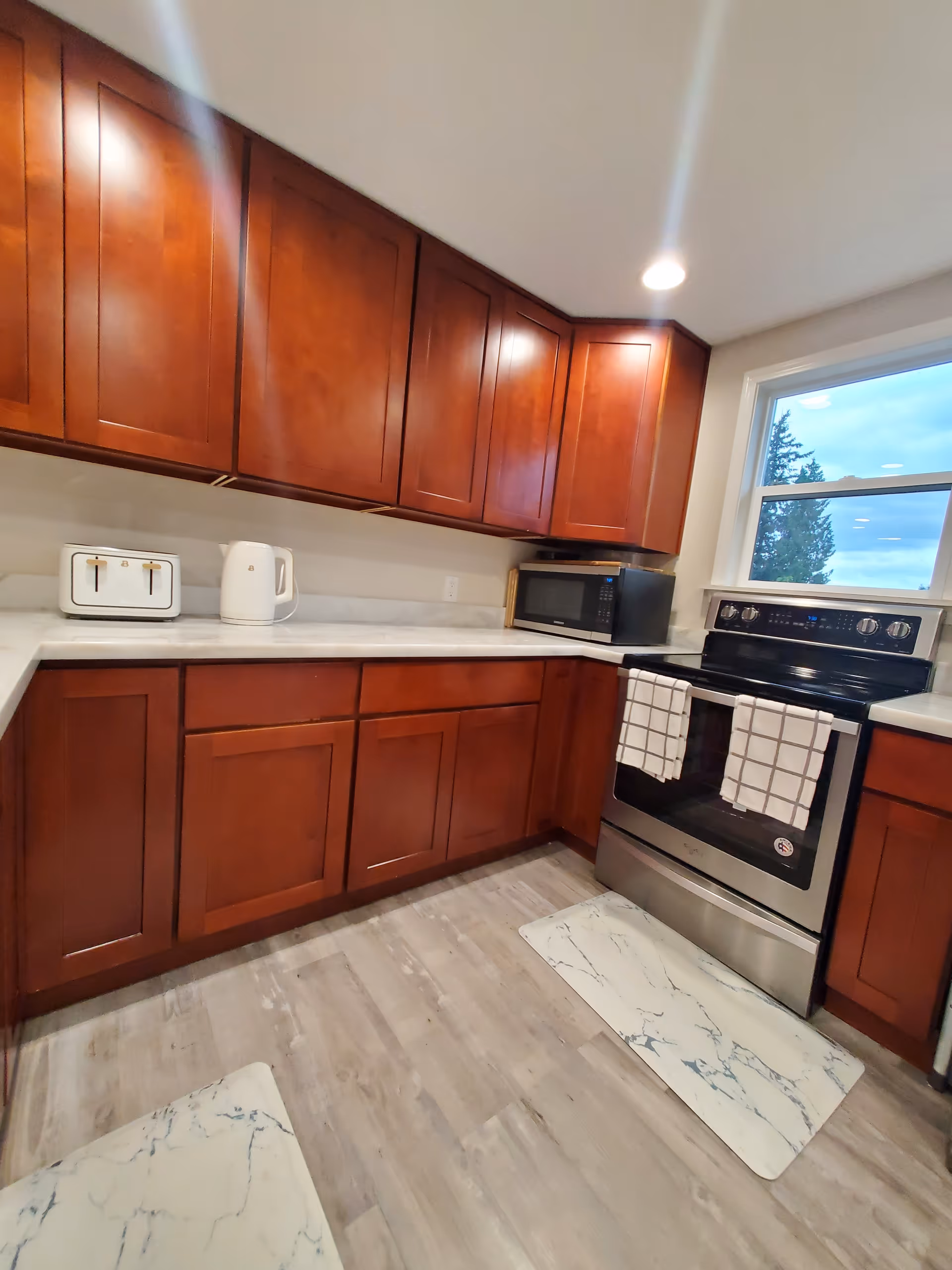 U-shaped kitchen with dark wood cabinets, countertop appliances, and a window.