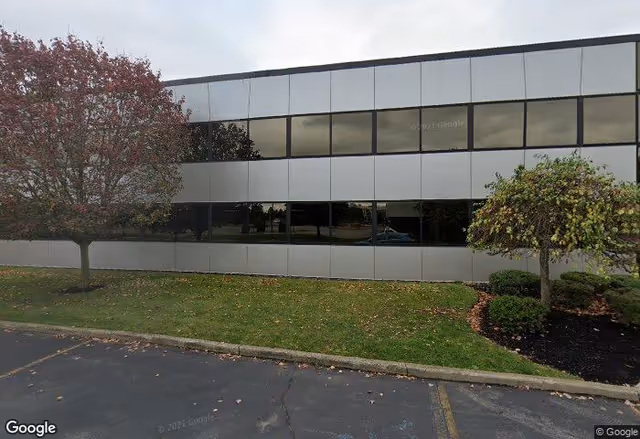 Exterior view of a modern building with large windows and trees.