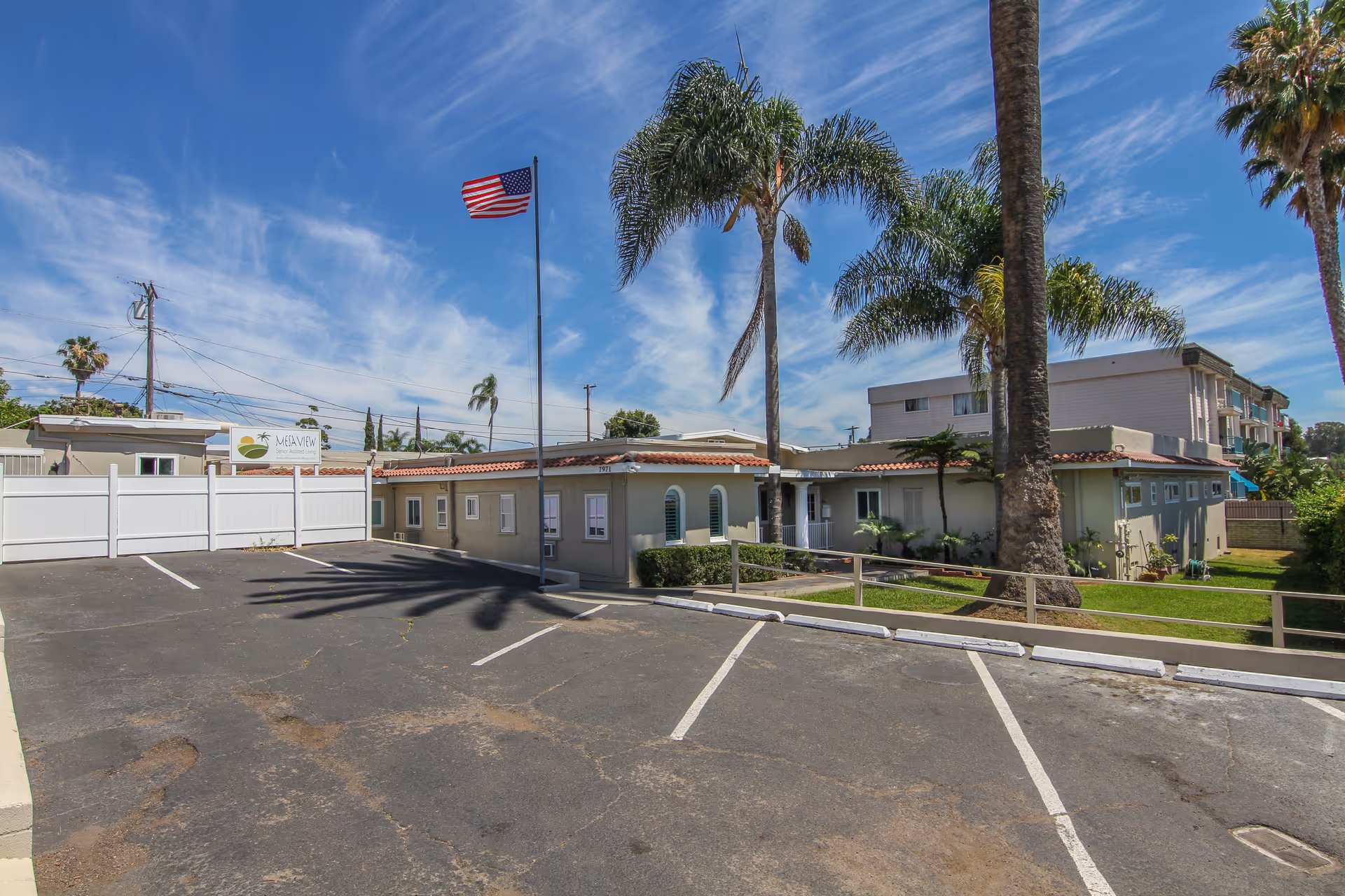 Front exterior view of Mesaview Senior Assisted Living with parking and palm trees.