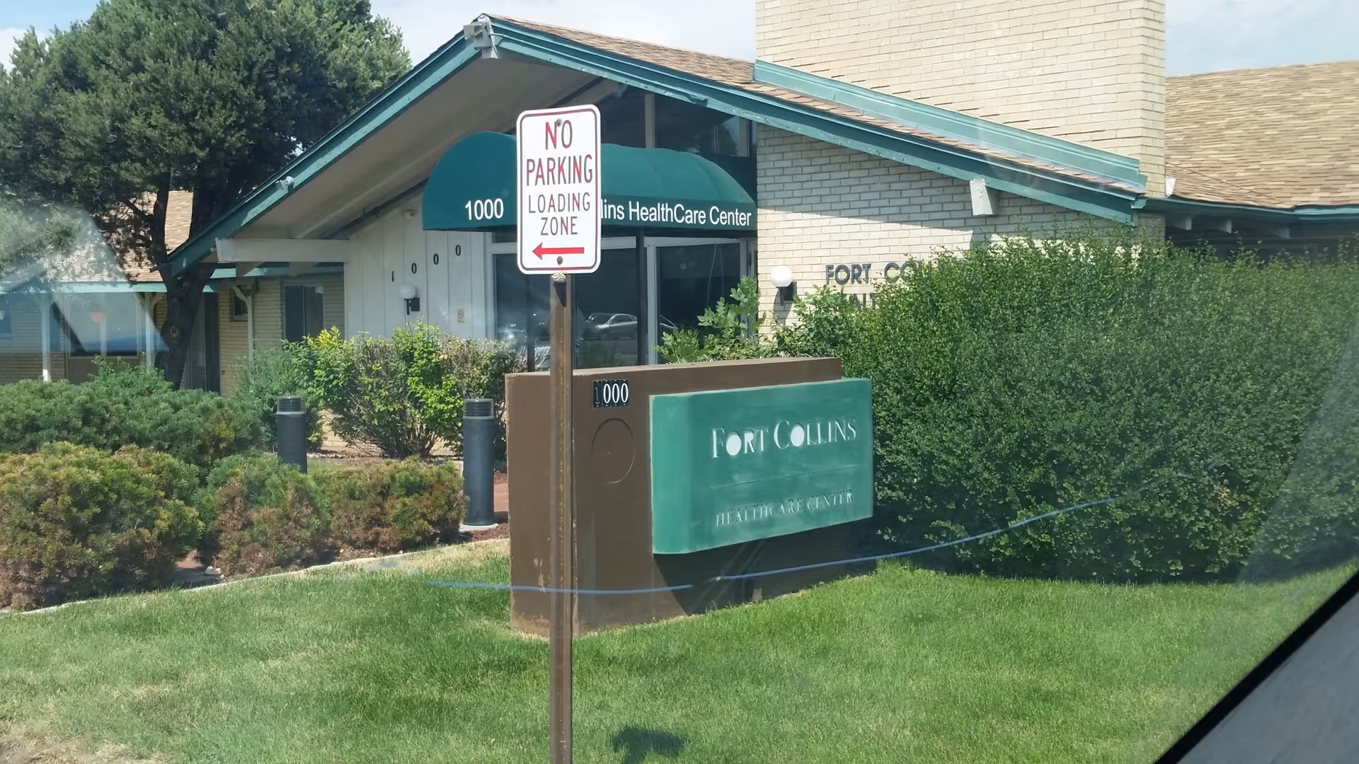 Front view of a senior care center with a large Fort Collins sign and landscaping.