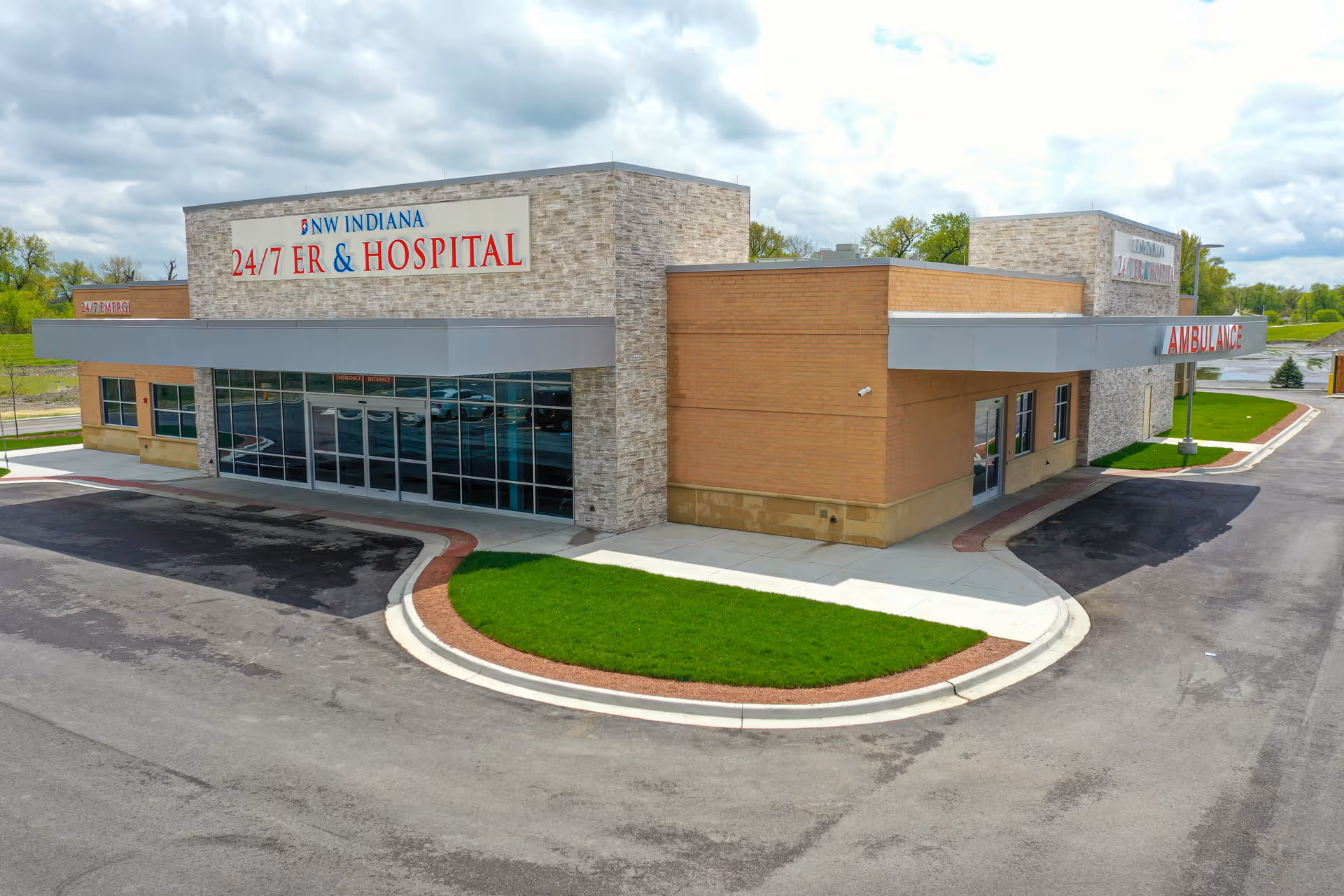 Front exterior of NW Indiana ER & Hospital with glass entrance and circular driveway.