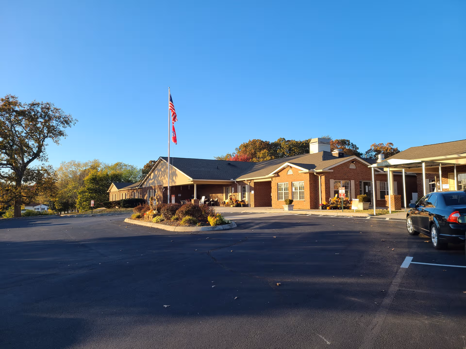 Exterior view of Jamestowne Assisted Living with brick building and flagpole in parking lot