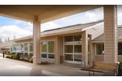 Front entrance of Life Care Center of Port Townsend with glass doors and a bench.