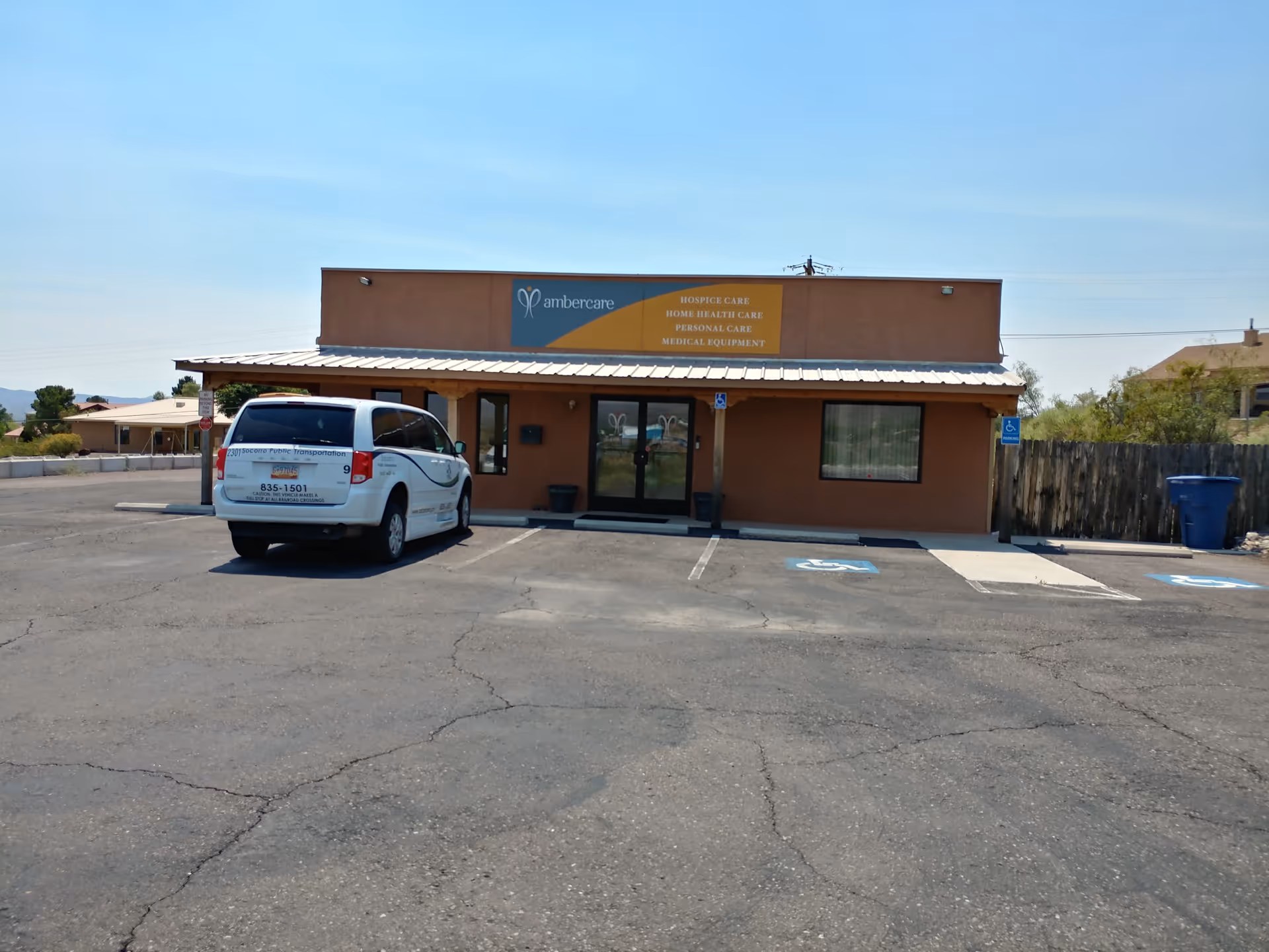 Ambercare Home Health building exterior with beige storefront, sign, parking lot, and a white van.