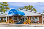 Exterior view of Heartland at Peoria senior living facility with blue awning.