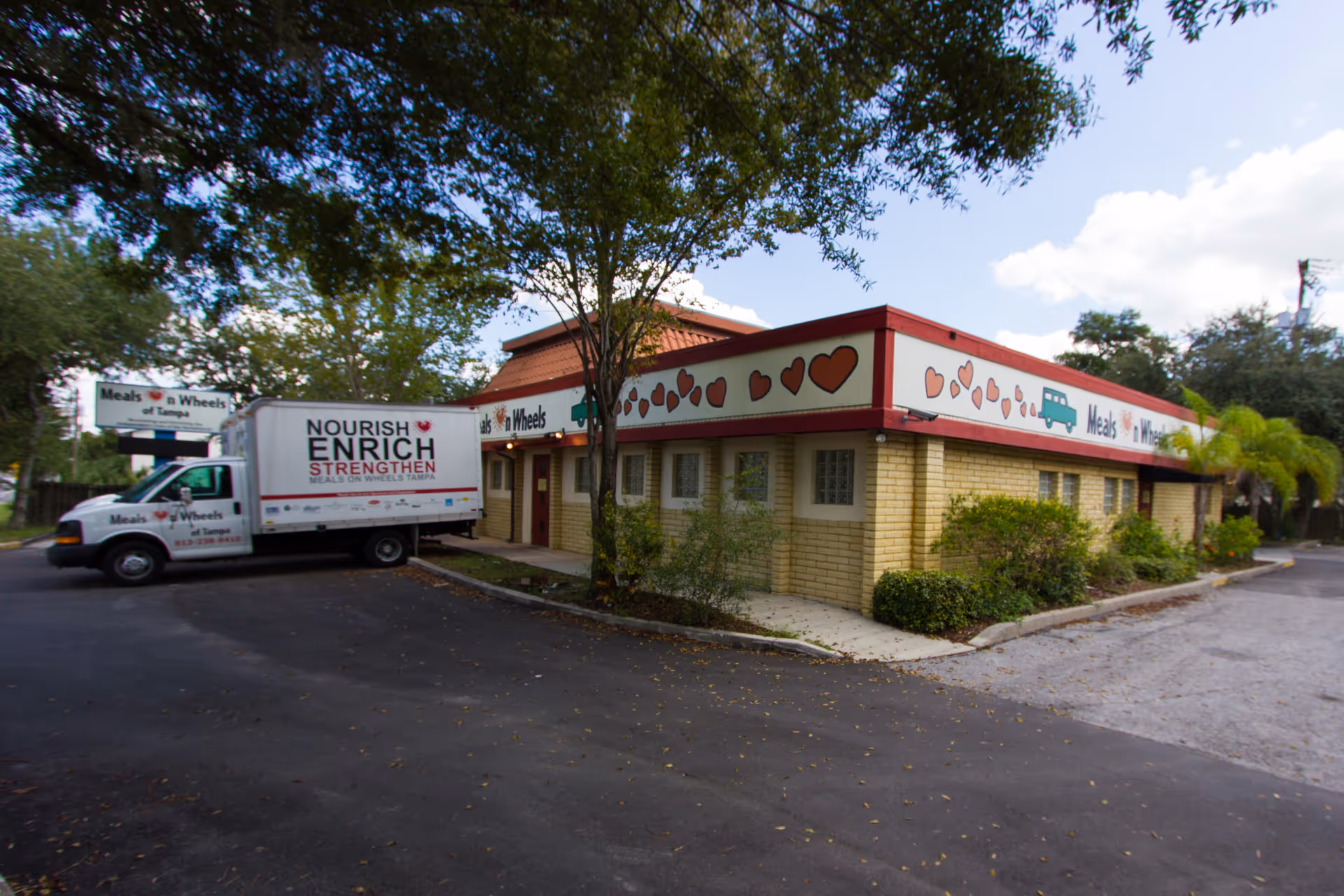 Exterior view of a Meals on Wheels of Tampa building with a delivery truck nearby