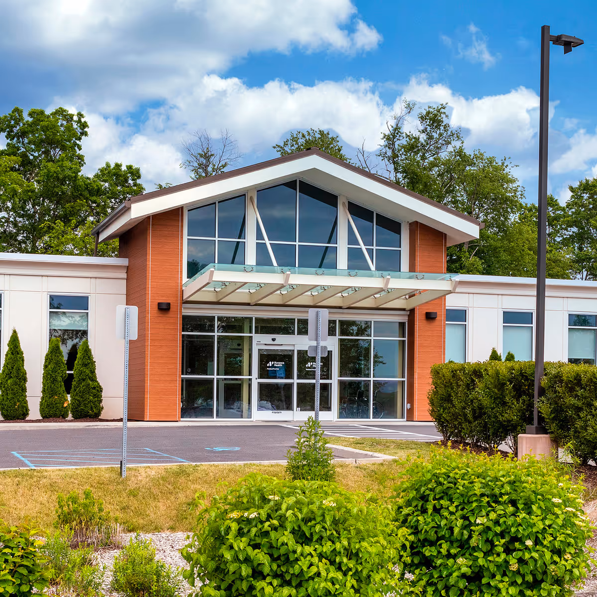Nuvance Health Primary Care Highland exterior with glass entrance and landscaped surroundings.