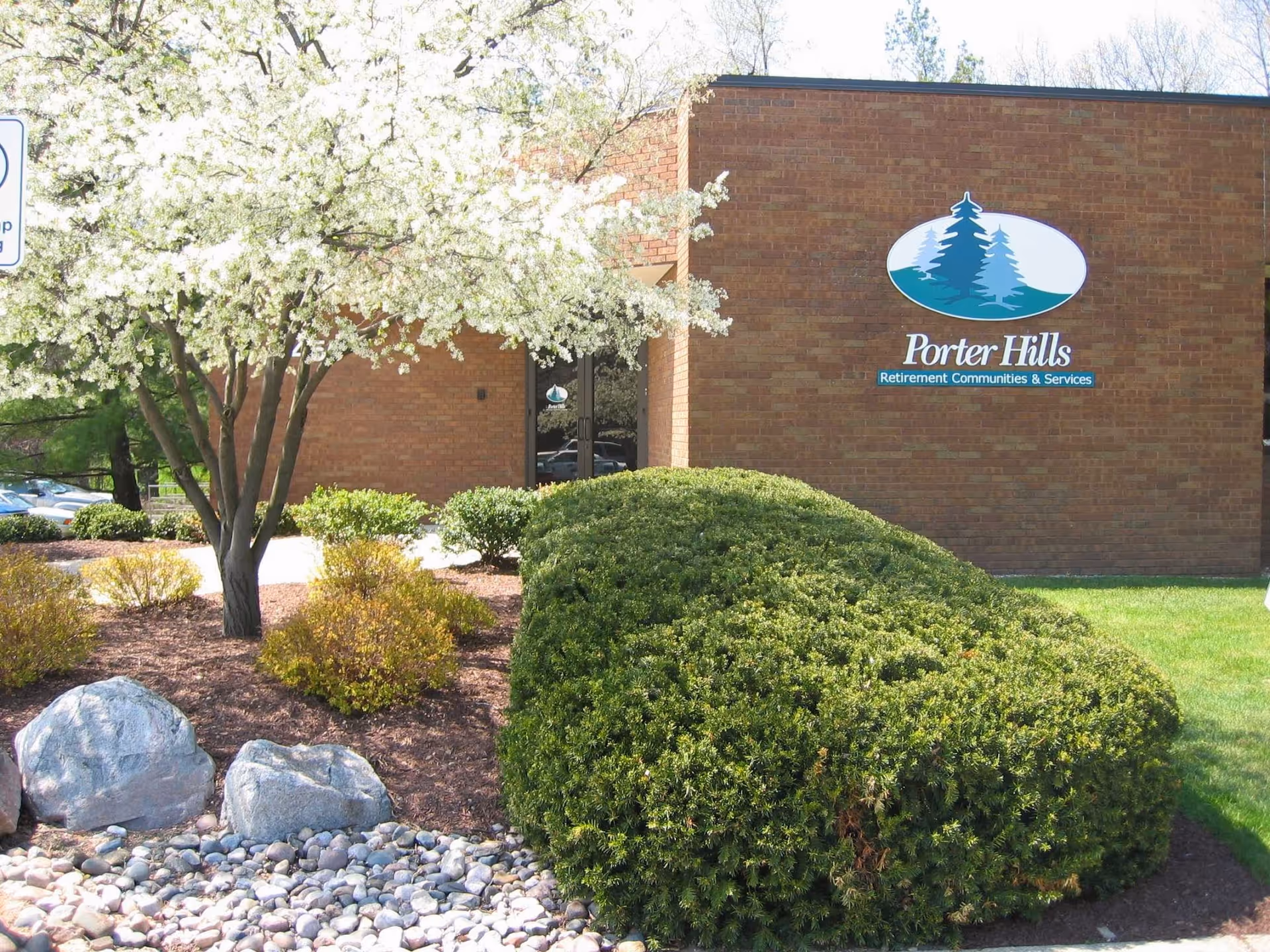 Brick building with Porter Hills sign, landscaped front yard and flowering tree.