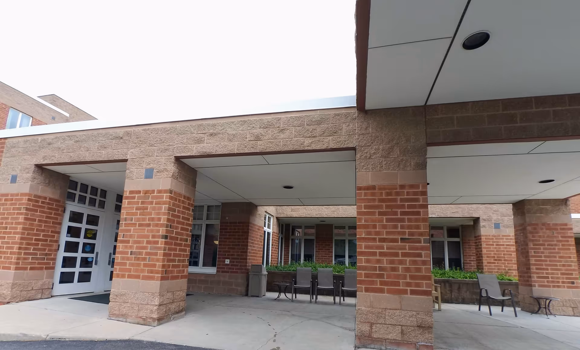 Exterior view of Villa St. Francis entrance with brick columns and a covered walkway.