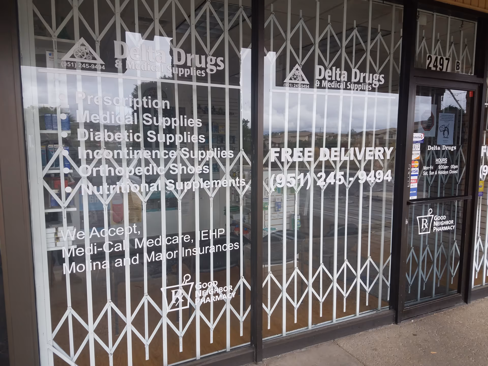 Storefront display for Delta Drugs & Medical Supplies with white signage and metal security bars.