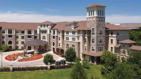 Atria Canyon Creek exterior view of a multi-story brick facility with a circular driveway and grounds.