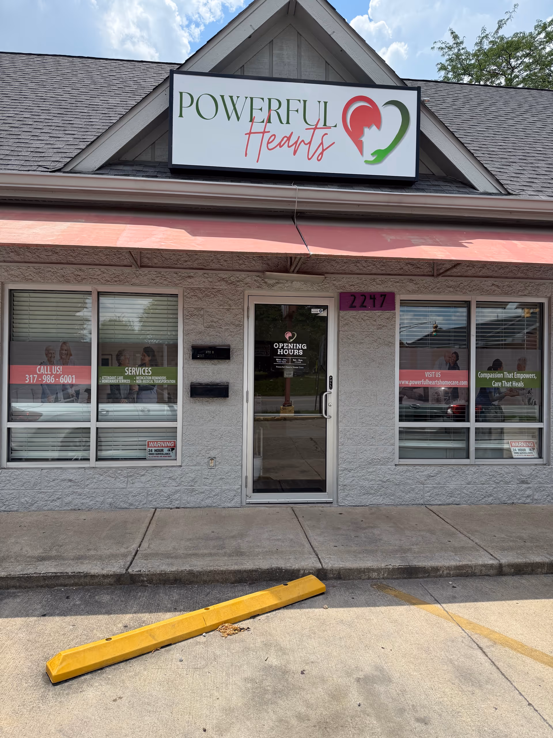 Exterior storefront with Powerful Hearts sign and glass door entrance.