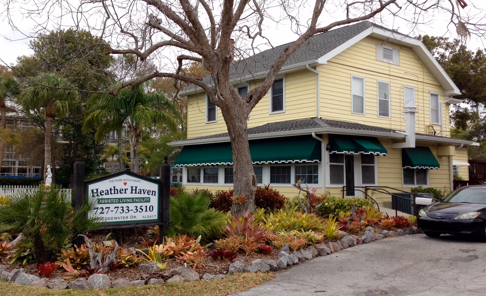 Exterior view of Heather Haven Assisted Living building with sign and landscaped front yard.