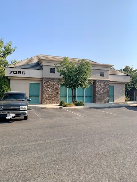 Front view of a single-story facility with stone accents and a parking lot.