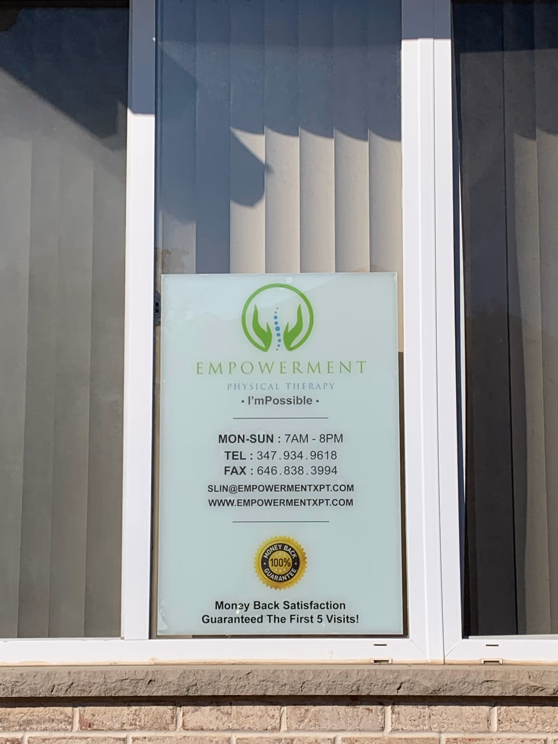 Front storefront window sign for Empowerment Physical Therapy displaying contact details