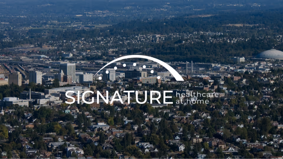 Aerial cityscape with Signature Healthcare at Home logo overlay across skyline
