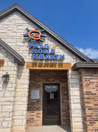 Front exterior of a PALS Home Health building with stone facade and sign