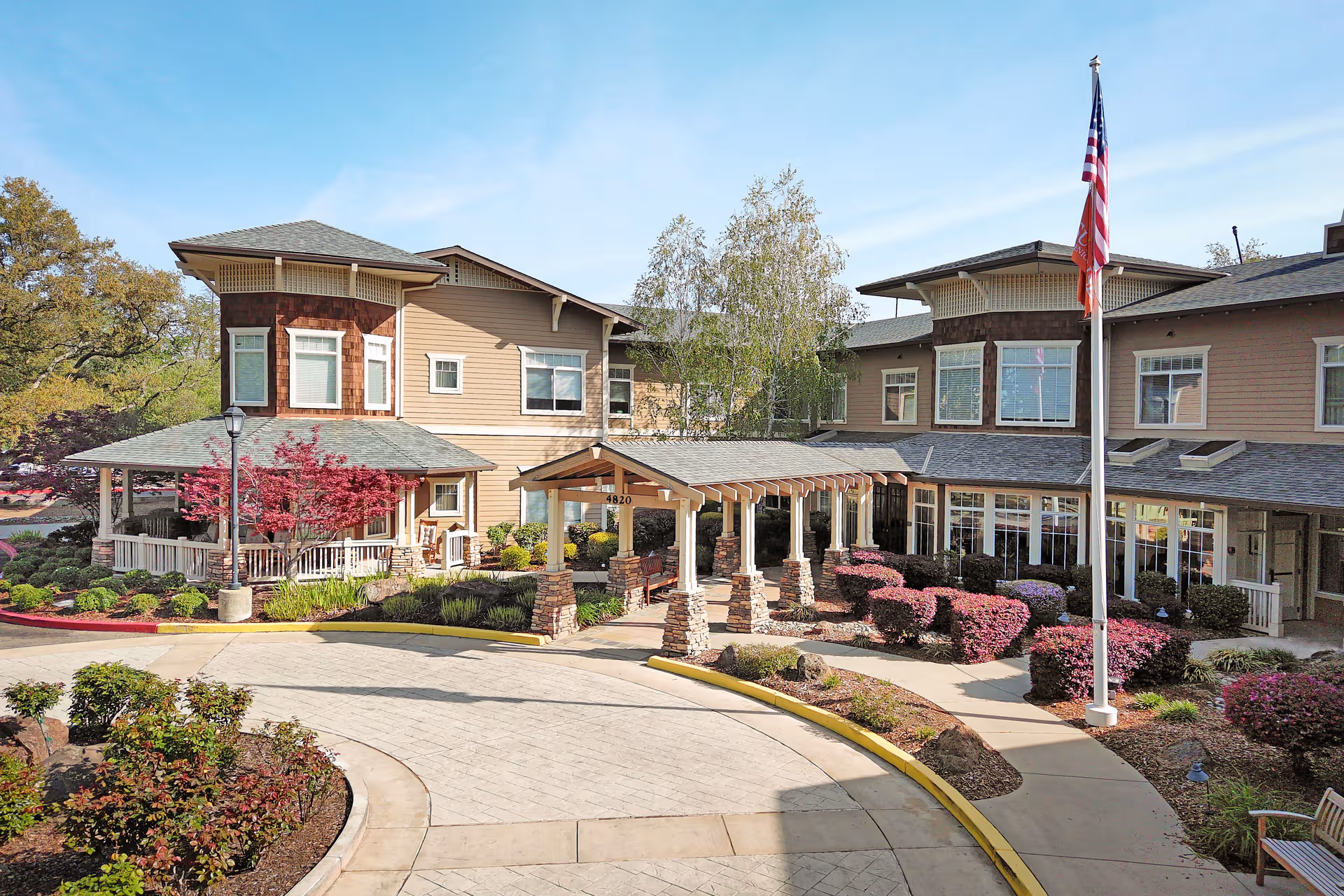 Exterior view of Sunrise of Fair Oaks facility with entrance, landscaping, and flag.