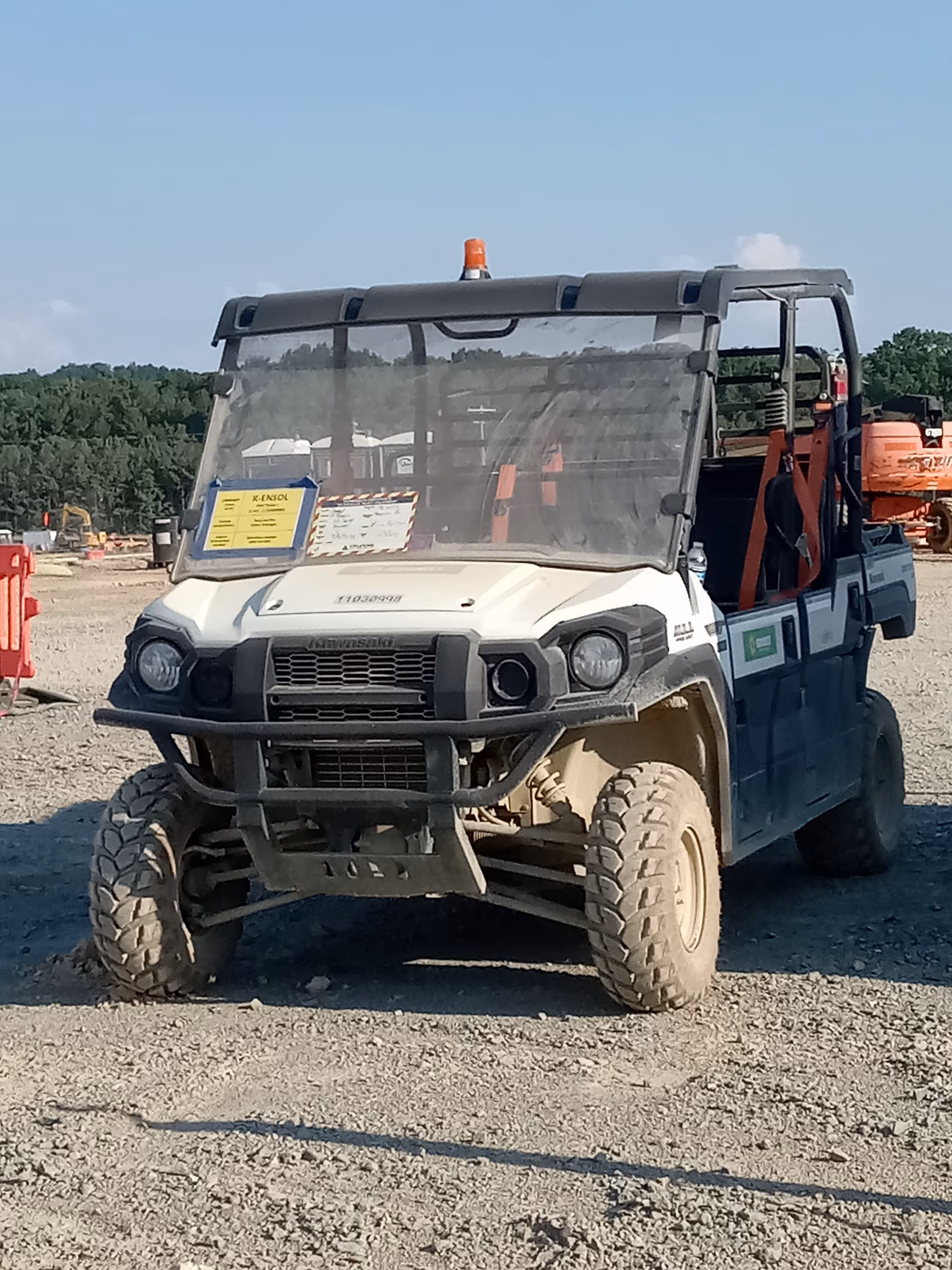 Front view of a rugged off-road utility vehicle on a gravel construction site outdoors.