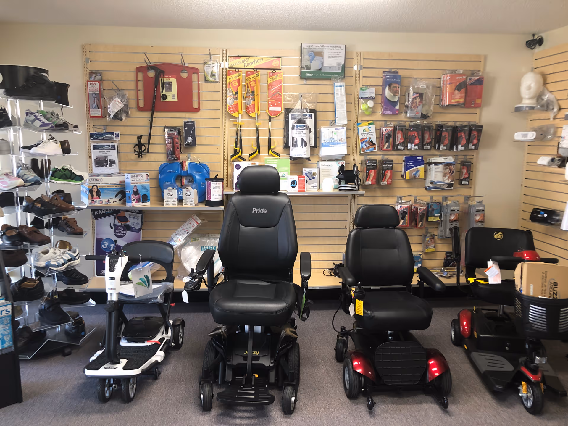 Interior showroom with mobility scooters, walkers, and medical supplies on wall display panels.