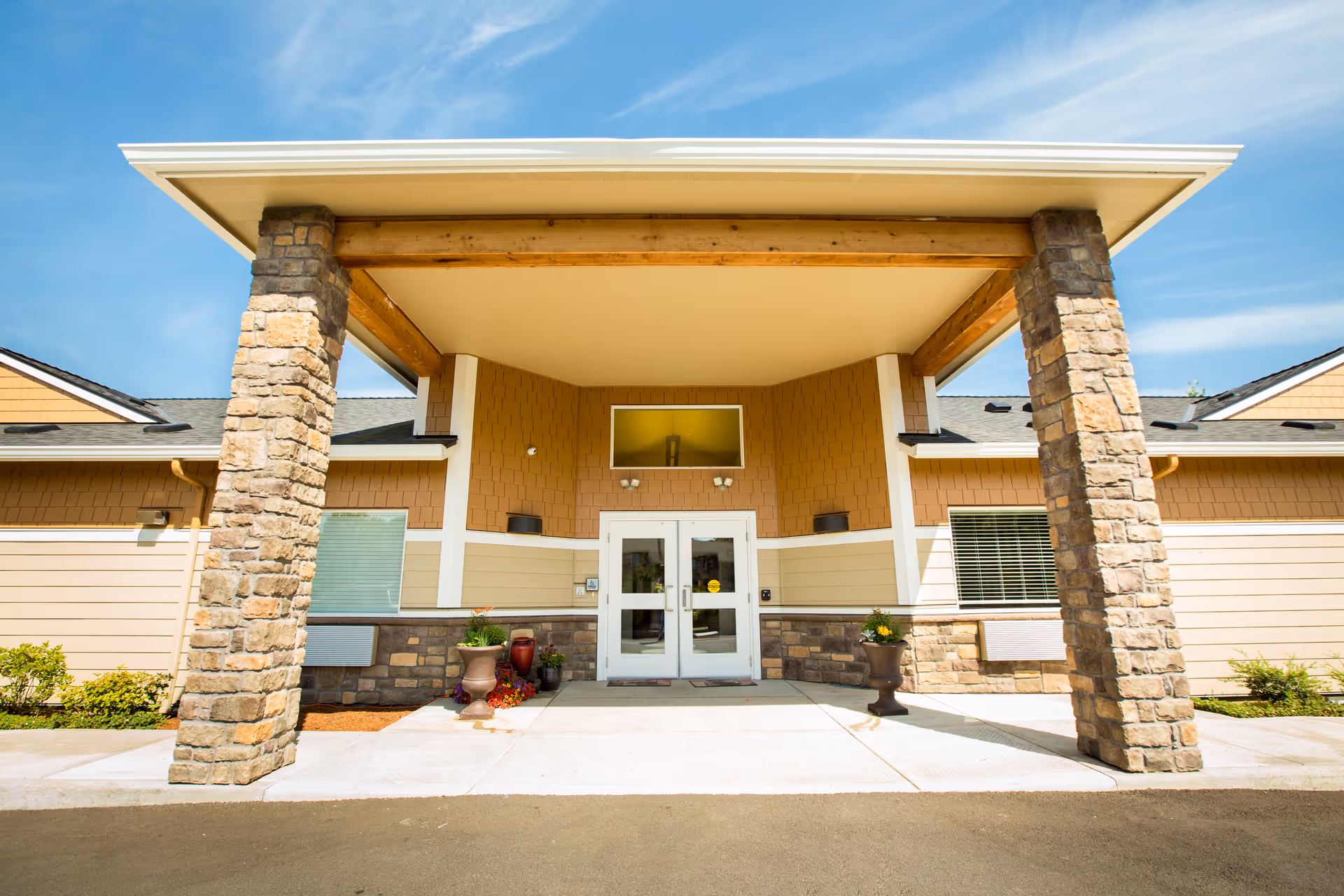 Exterior view of the Coral Springs and Reflections Memory Care entrance with stone pillars.